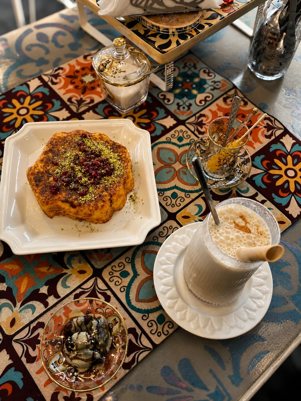 Persian cake, tea and sweets on a patterned café table