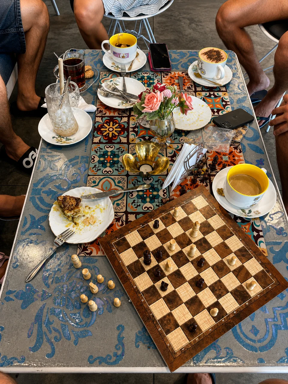 A colourful café table set for tea and chess