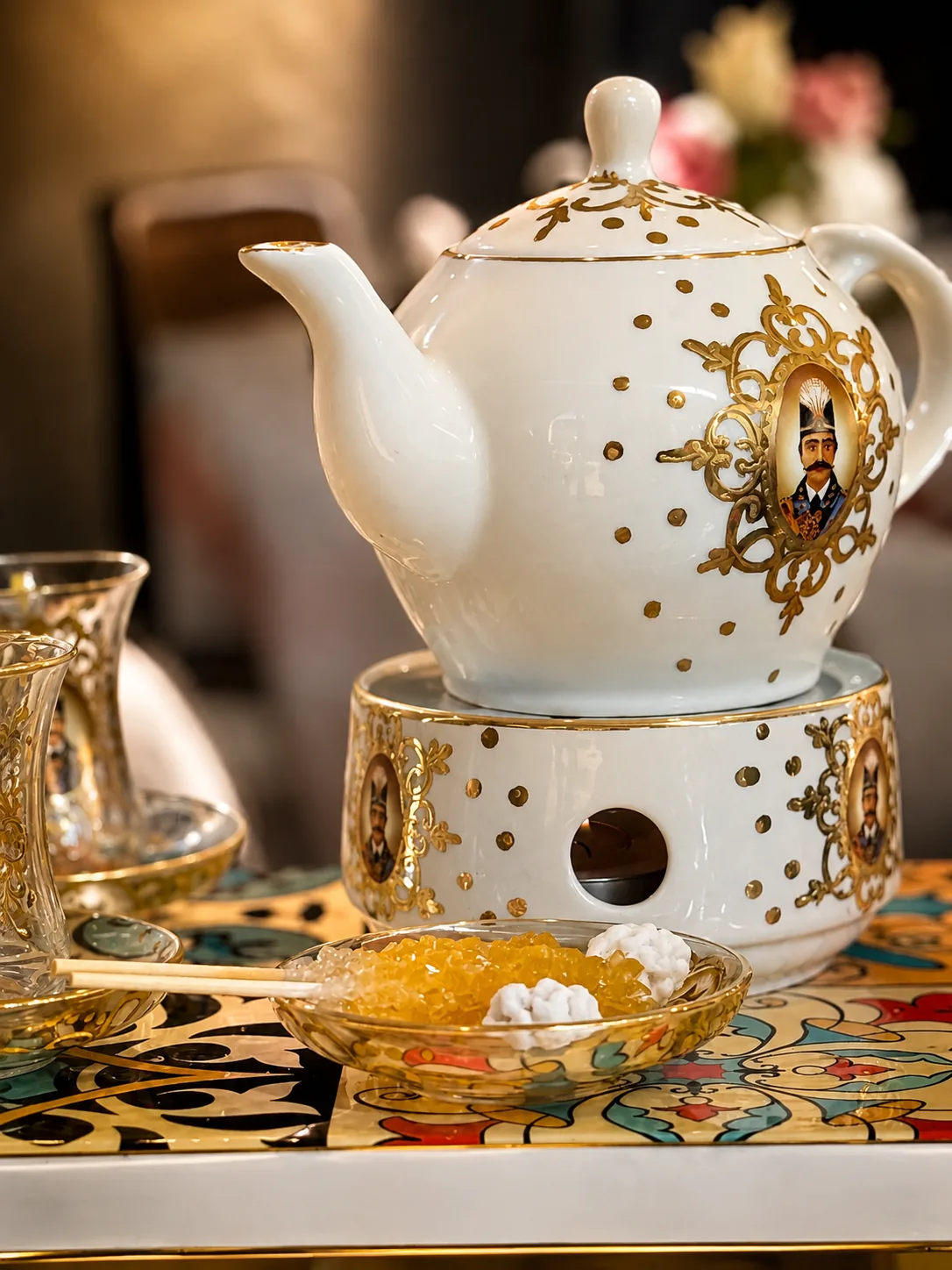 Ornate Persian teapot and sugar crystals on a colourful café table
